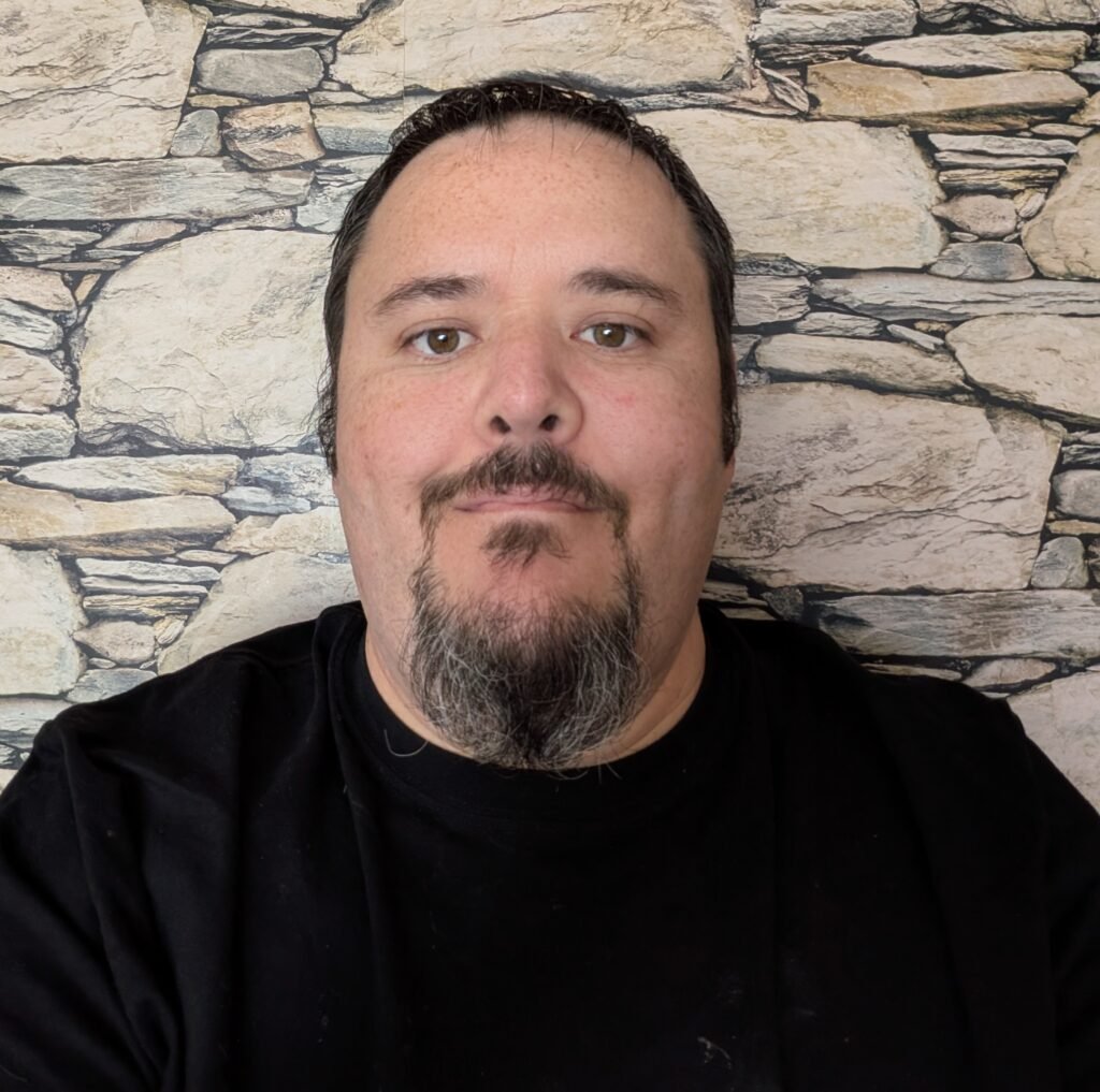 Image of a man with a black t-shirt and a stone back ground